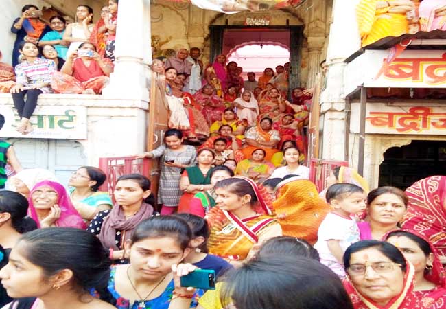 हिन्दू धर्मयात्रा का स्वागत करने और निहारने के लिए दाऊजी मंदिर के आगे और सीढिय़ों पर बैठी महिलाएं।