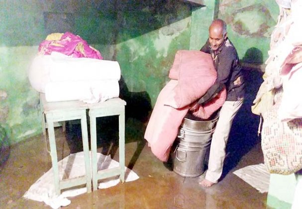 मोहता चौक स्थित दुकान के तलघर में भरे पानी से खराब हुए सामान को बाहर निकालते। फोटो : राहुल व्यास