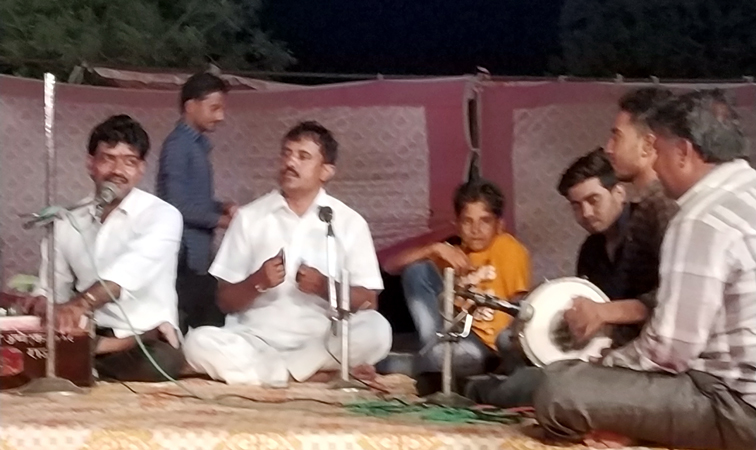 बीकानेर में भीनासर स्थित श्रीगणेश धोरा धाम प्रांगण में गुरु पूर्णिमा के अवसर पर आयोजित जागरण में भजनों की प्रस्‍तुति देते गायक कलाकार। 